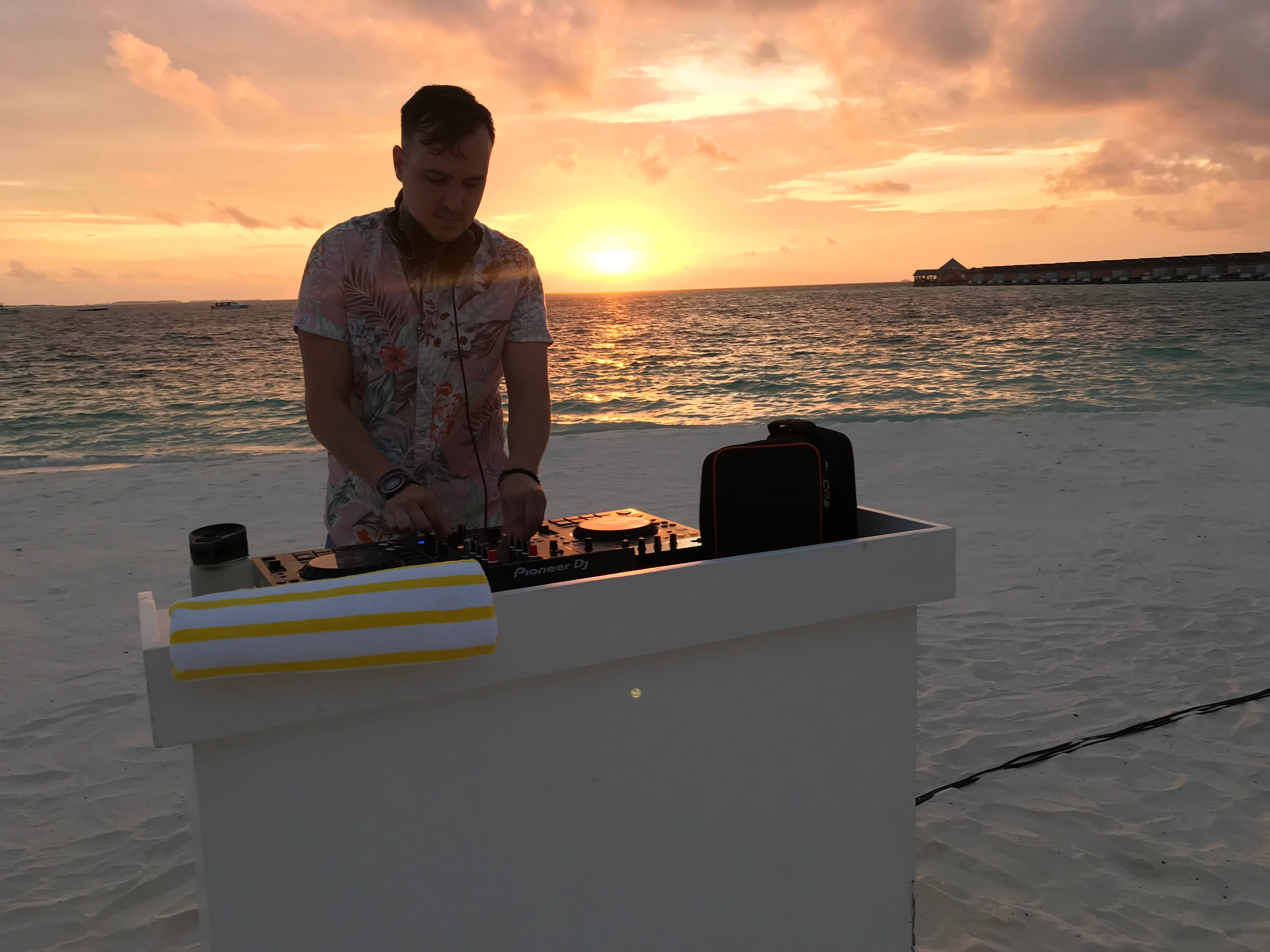 Table Manners DJing at sunset with the Auxinn bag on the booth in the Maldives